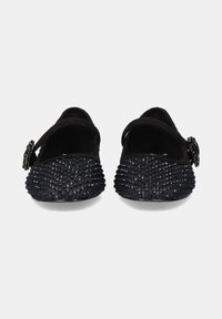 Bailarinas negras con un upper texturizado que presenta lentejuelas, puntera redonda y una pequeña correa con un acento de hebilla decorativa.