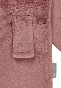 Soft plush fabric in muted pink, featuring a small integrated pocket. Textured surface with a smooth feel and stitched edge for durability.