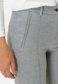 Gray tailored trousers with textured fabric, featuring a flat front, side pockets, and a button closure. Neat stitching visible along seams.