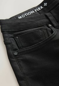 Zwarte denim jeans met een vlakke voorkant, vijf-pocket ontwerp en subtiele stikdetails. De tailleband bevat 'MOTION FLEX' branding.