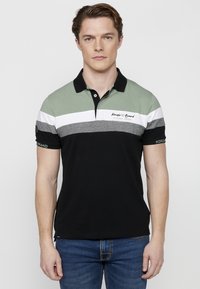Pánska polo tričko s dizajnom v zeleno-čiernych blokoch, textil s textúrou a vyšitým logom na hrudi. Krátke rukávy, golier a slim fit.