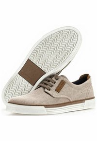 Canvas-Sneaker mit beigem Obermaterial, braunen Akzenten, runden Schnürsenkeln und einer weißen Gummisohle mit Fischgrätenprofil.