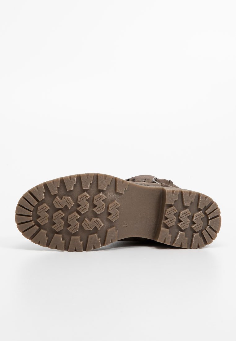 Suela de bota de goma marrón con un patrón de taco texturizado para tracción. Presenta una forma redondeada y bordes reforzados para mayor durabilidad.