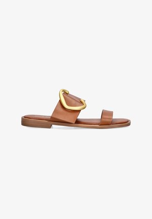 Sandaña deslizante de cuero marrón con una amplia tira y un gran detalle de hebilla dorada, suela plana y diseño minimalista.