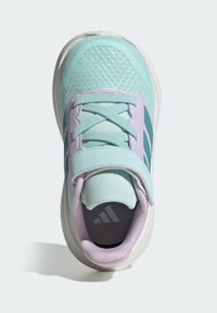 Αθλητικό παπούτσι ανοιχτού γαλάζιου χρώματος με ανώτερο μέρος από δίχτυ και ύφασμα, με μοβ λεπτομέρειες, λουράκι με βέλκρο και λευκή σόλα με υφή.