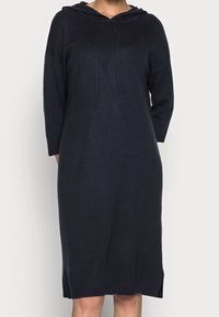 Huvtröjdress i mörk marinblå, tillverkad av ett mjukt stickat tyg. Har långa ärmar, en avslappnad passform och sprund i nederkanten.