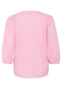 Top à manches bouffantes en tissu rose doux avec des motifs en cœur subtils, col rond et poignets élastiques. Fini léger et texturé.
