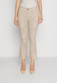 Beige suède broek met een getailleerde taille, een lichte flare aan de zoom en een enkele knoopsluiting aan de voorkant. Soepele textuur, geen zichtbare patronen.