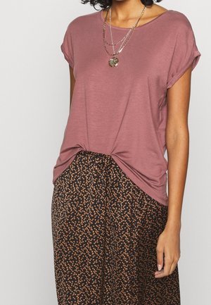 Korte mouw, mauve top met een gedraaide knoopdetail aan de onderkant, gecombineerd met losse zwarte broek met een klein, oranje bloemmotief.