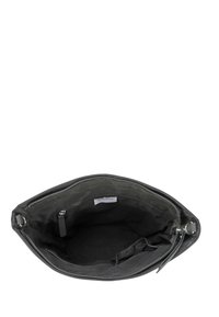 Sort stof handbag med lynlåslukning, en indvendig lomme og sølvhardware. Indvendigt har den en glat tekstur og et labelmærke.