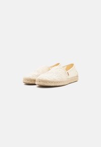Espadrilles en dentelle avec un motif floral blanc, bout rond, semelle en jute tissée et accents beiges, idéales pour un usage décontracté.