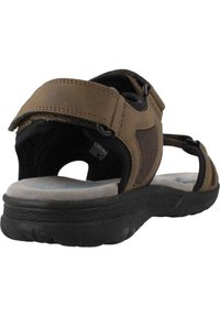 Sandaña marrón de múltiples correas con una plantilla suave y acolchada y suela de goma texturizada. Presenta correas de Velcro ajustables para un ajuste seguro.