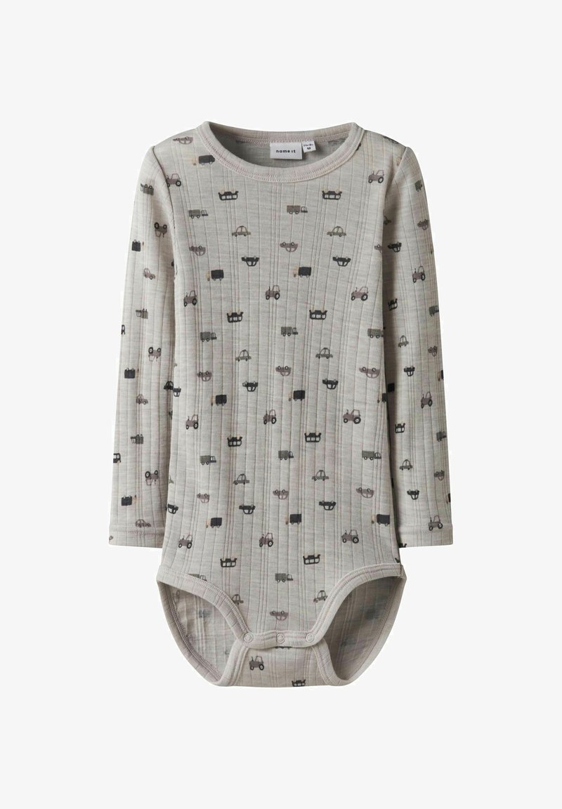 Duguljasti kombinezon dugih rukava u svijetlosivoj rebrastoj tkanini sa raznim uzorcima vozila u tamnosivoj i crnoj boji, sa zakovicama na dnu.