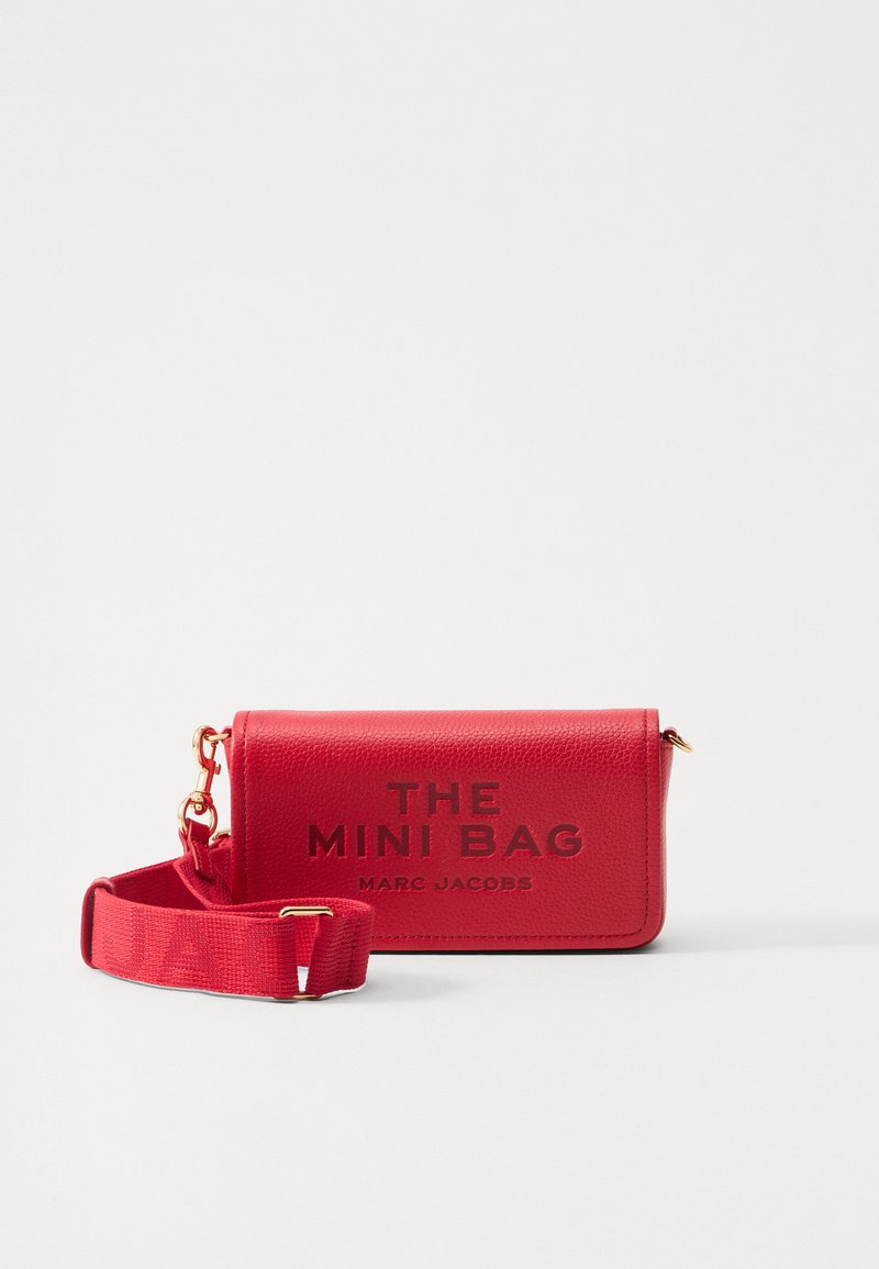 Mini borsa in pelle rossa con tracolla regolabile, hardware dorato e "THE MINI BAG MARC JACOBS" stampato sul davanti.