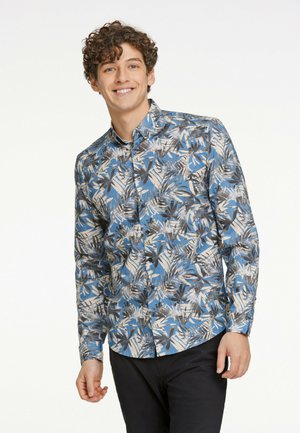 Camisa de botón con fondo azul, que presenta un patrón de hojas tropicales en negro y crema. Mangas largas con cuello estándar.