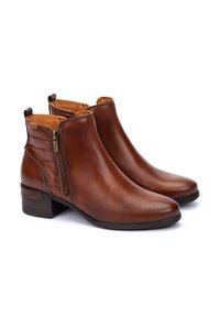 Bruna läderankelboots har en slät yta, spetsig tå och en sidoberlock med en texturerad krokodilmönstrad detalj på hälen.