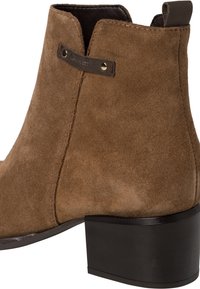 Stivale alla caviglia in suede marrone con punta arrotondata, tacco a blocco nero di 5 cm, dettagli cuciti e una targhetta in pelle davanti.