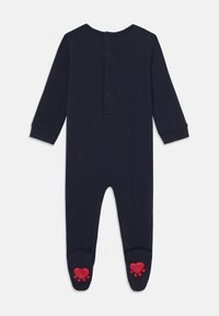 Mørkeblå baby-heldress, lange ermer, trykknaplukking bak, design med føtter og røde hjerteaccenter på sålene, myk stoff.