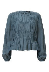 Blusa azzurro chiaro a maniche lunghe con texture arricciata, scollo rotondo e orlo a peplum. Il tessuto appare morbido e liscio.