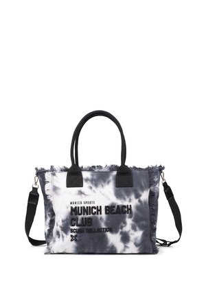 Bolsa tote de lona tie-dye con asas negras, bordes con flecos y correa de hombro negra desmontable. El texto dice "Munich Beach Club Scuba Collection."