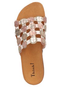 Flache Riemensandale mit weißen Riemen, verziert mit metallischen, münzähnlichen Akzenten in Roségold- und Silbertönen. Brauner strukturierten Fußbett.