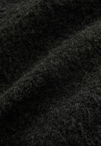 Texturiertes schwarzes Gewebe mit einer weichen, flauschigen Oberfläche, die eine Nahaufnahme von Fasern zeigt und eine reiche, taktile Qualität vermittelt.