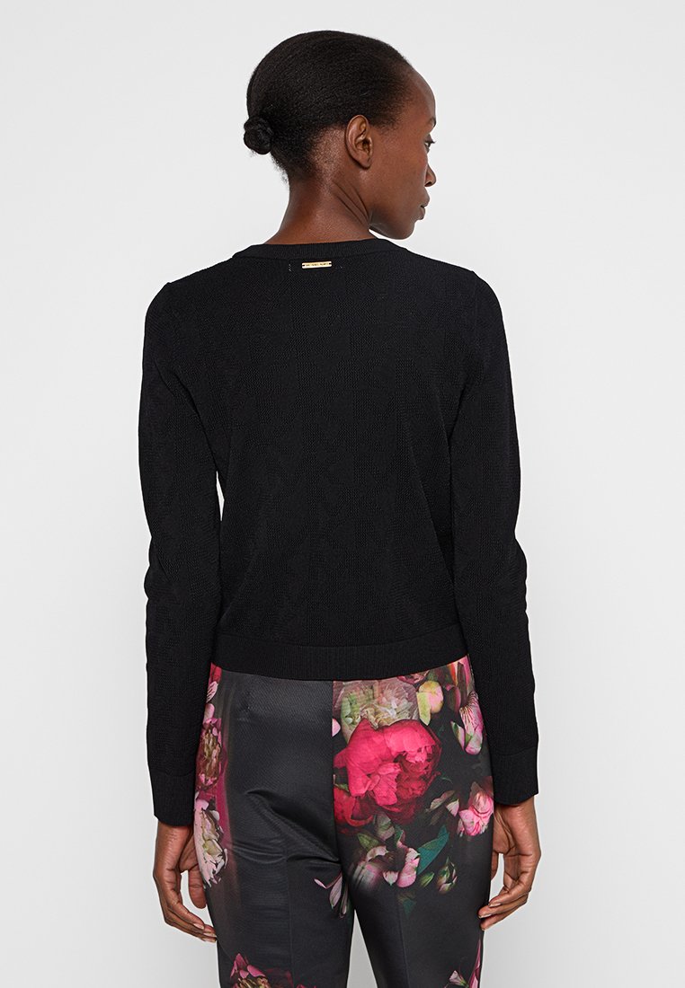 Maglione nero lavorato a maglia con scollo rotondo, orlo e polsini a costine, caratterizzato da un sottile motivo testurizzato e da un piccolo logo del marchio in tonalità oro sul retro.