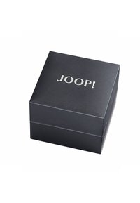 Zwarte, gestructureerde doos met een gladde, matte afwerking. Voorzien van een reliëf zilveren "JOOP!" logo op de bovenkant. Vierkante vorm met strakke lijnen.