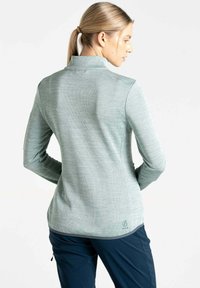 Langärmliges, mintgrünes Oberteil mit hohem Kragen, strukturiertem Stoff und subtiler Logo-Details am Saum. Figurumspielender Schnitt mit dehnbarem, atmungsaktivem Material.