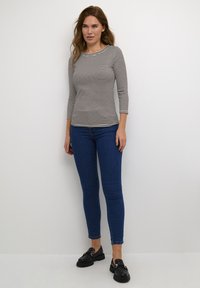 Ribakangas pikem sleeves musta ja valge triibuga, kinnihoitud vaherind, kombineeritud siniste kitsaste teksade ja mustade platvormkingadega.