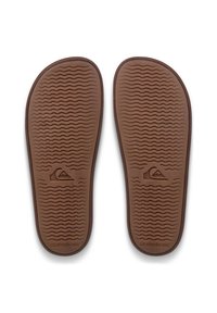 Bruine rubberen inlegzolen met een getextureerd golfpatroon en afgeronde randen, met een Quiksilver-logo aan de rechterkant in een lichtere tint.