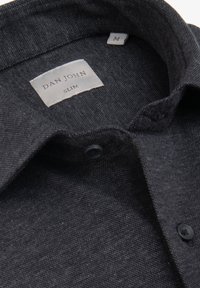 Mørkegrå kortærmet skjorte. Tekstureret stof med en slank pasform, der har en lille krave, to knapper og et mærke med teksten "Dan John Slim."