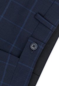 Granatowa tkanina w kratkę z jasnoniebieskimi liniami, z guzikami i płaską kieszenią. Teksturowana powierzchnia z dopasowanym fasonem.