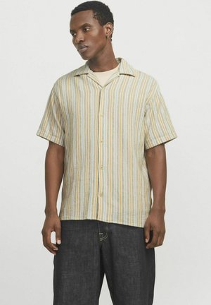 Chemise à manches courtes en tissu texturé avec des rayures verticales pastel, dotée d'un col classique et d'une fermeture à boutons. Porte avec un pantalon en denim foncé.