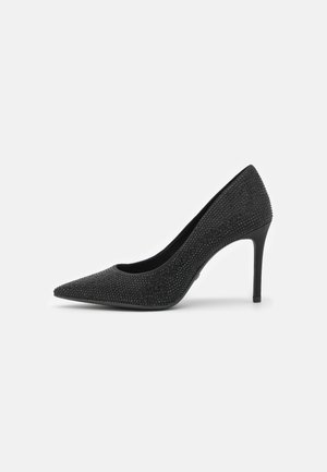 Schwarzer High-Heel-Pumps mit spitzer Spitze, bedeckt mit kleinen schwarzen Strasssteinen, von der Außenseite vor weißem Hintergrund gezeigt.