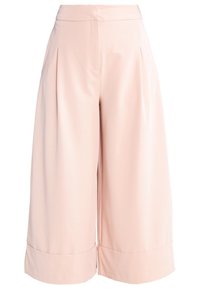 Pantalon court taille haute à jambes larges, rose clair, avec plis et ourlets larges.