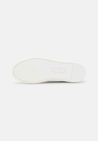 White sneaker sole with herringbone tread pattern and rectangular logo area on a plain white background.