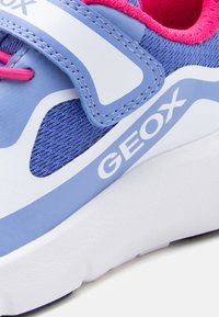 Μπλε και λευκό αθλητικό παπούτσι Geox με ροζ λεπτομέρειες, διαθέτει ύφασμα από δίχτυ, λουράκι με αγκράφα και παχύ λευκό πέλμα.