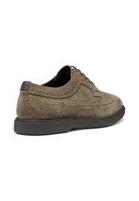 Scarpa in suede marrone con lacci, dettagli brogue, punta arrotondata, suola in gomma nera e dettagli in pelle scura sul tallone.