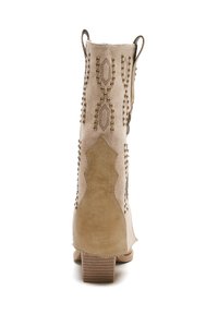 Botín beige de tobillo hecho de cuero texturizado, con tachuelas decorativas y patrones de diamante. Tacón cuadrado y tiradores para facilitar el calzado.