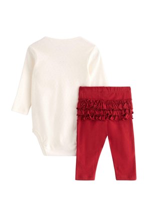 Wit longsleeve bodysuit met een textuurpatroon, gecombineerd met rode leggings met een gerimpelde tailleband in dezelfde kleur.
