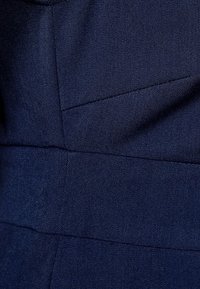 Laudankankaan, jossa on sileä rakenne, esittää geometrisia saumoja ja yksinkertaista muotoilua. Materiaali näyttää kestävältä ja rakenteelliselta, mukautetut yksityiskohdat.