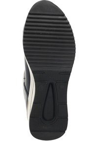Semelle de chaussure noire avec texture nervurée, comportant une bande d'accent beige. Contient des logos circulaires et rectangulaires au bas pour l'adhérence.