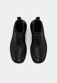 Černé kožené boty s hladkým povrchem, šněrovací design, zaoblená špička, polstrovaný límec a kontrastní modré akcenty na vršku.