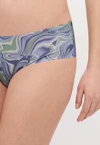 Costumi da bagno nella parte inferiore con un motivo a vortice multicolore che presenta tonalità di verde, blu e bianco. Vita elastica con un accento del logo. Tessuto morbido.