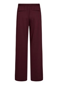 Bordeaux wijde beenbroek van zachte stof; heeft een elastische tailleband en twee achterzakken voor opbergruimte. Gladde textuur, geen zichtbare patronen.