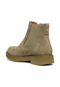 Stivaletto in suede beige con pannelli elastici laterali, punta rotonda e suola in gomma. Design minimalista con texture a contrasto sui pannelli.