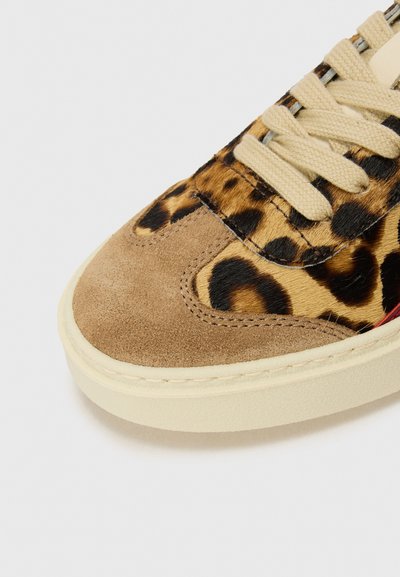 Sko med leopardmønster, suede tåhætte, cremefarvede snørebånd og kontrasterende gummisål. Har tekstureret pels og syede detaljer.