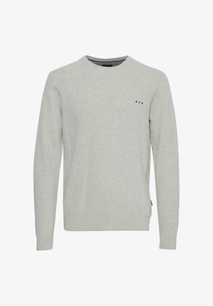 Gaišpelēka adīta džemperis ar apaļu kakla izgriezumu, ribotām piedurknēm un nelielu izšūtu logotipu sarkanā, baltā un zilā krāsā uz krūtīm.