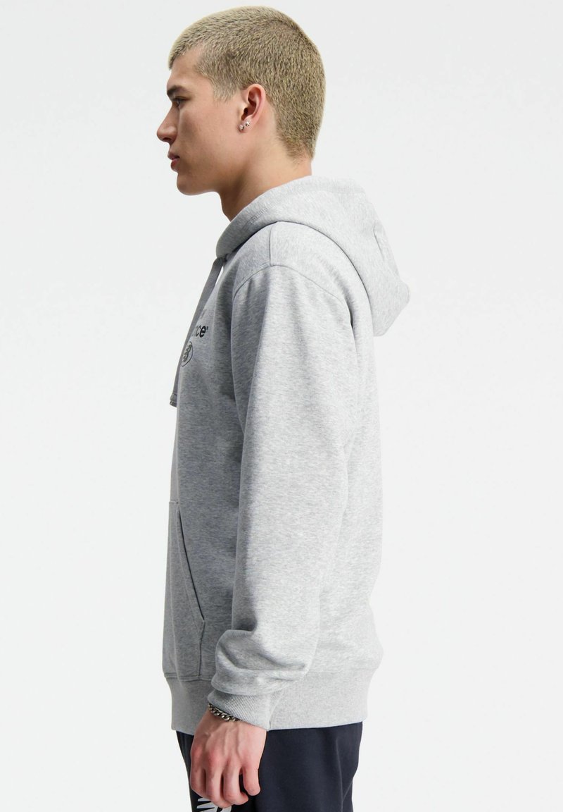Szara bluza z kapturem wykonana z miękkiego materiału, z kieszenią kangurzą, kapturem ze sznurkiem i ściągaczami na rękawach. Minimalistyczny design z detalem logo.